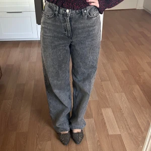 Gråa wide jeans med hög midja - Säljer ett par gråa jeans med tvättad look och hög midja. Modellen är wide och har klassiska fem fickor samt knapp och dragkedja framtill. Byxorna är väldigt stora i storleken, jag är vanligtvis en M/38 men jeansen är i storlek 34 så ha det i åtanke💓 