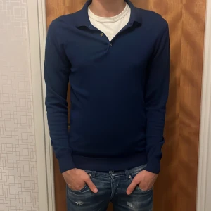 Mörkblå pikétröja! - Snygg mörkblå pikétröja från John henric. Tröjan är i ett jätte fint skick, har man frågor är de bara att höra av sig!