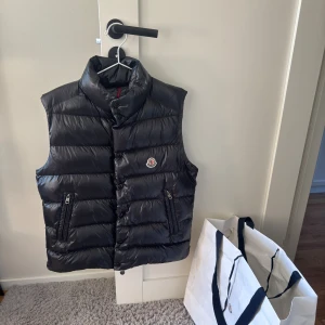 Moncler Tib Väst - Moncler Tib, Size 2 passar S/M, Cond 10/10 utöver väldigt litet hål (kolla sista bild), Retail 11000kr, Tveka inte på att skicka ett meddelande vid frågor eller liknande🤝