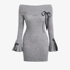 Grå ribbad offshoulder klänning - Oanvänd, endast prövad och upptvättad grå ribbstickad kortklänning med offshoulder och långa ärmar. Har svarta rosett-detaljer och det varma materialet är perfekt för hösten. Avklippt tagg men passar fint som en stl S.