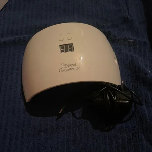 NG180 LED/UV All-in Lamp - NG180 LED/UV All-in Lamp från Nagelgiganten.se. Perfekt för gel- och shellac-naglar, med timerfunktion (30/60 sek), digital display och medföljande strömadapter. Lampan och originalkartong i gott skick, mindre ytslitage på kartongen.