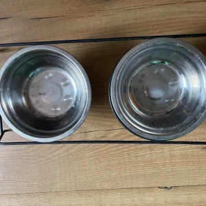 Två marskalkar med ställning  - Två rostfria skålar med tillhörande ställning, perfekta som mat- och vattenskålar för husdjur. Skålarna är  fullt funktionella. Ställningen håller skålarna stabilt på plats och underlättar matning.