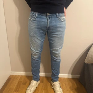 Replay Anbass ljusblå slim jeans - Säljer ett par Replay Anbass jeans i ljusblå tvätt med slim fit-passform. Klassisk femficksmodell med snygga detaljer på bakfickorna och bekväm stretch. Perfekt för dig som gillar en smal siluett och stilren look.