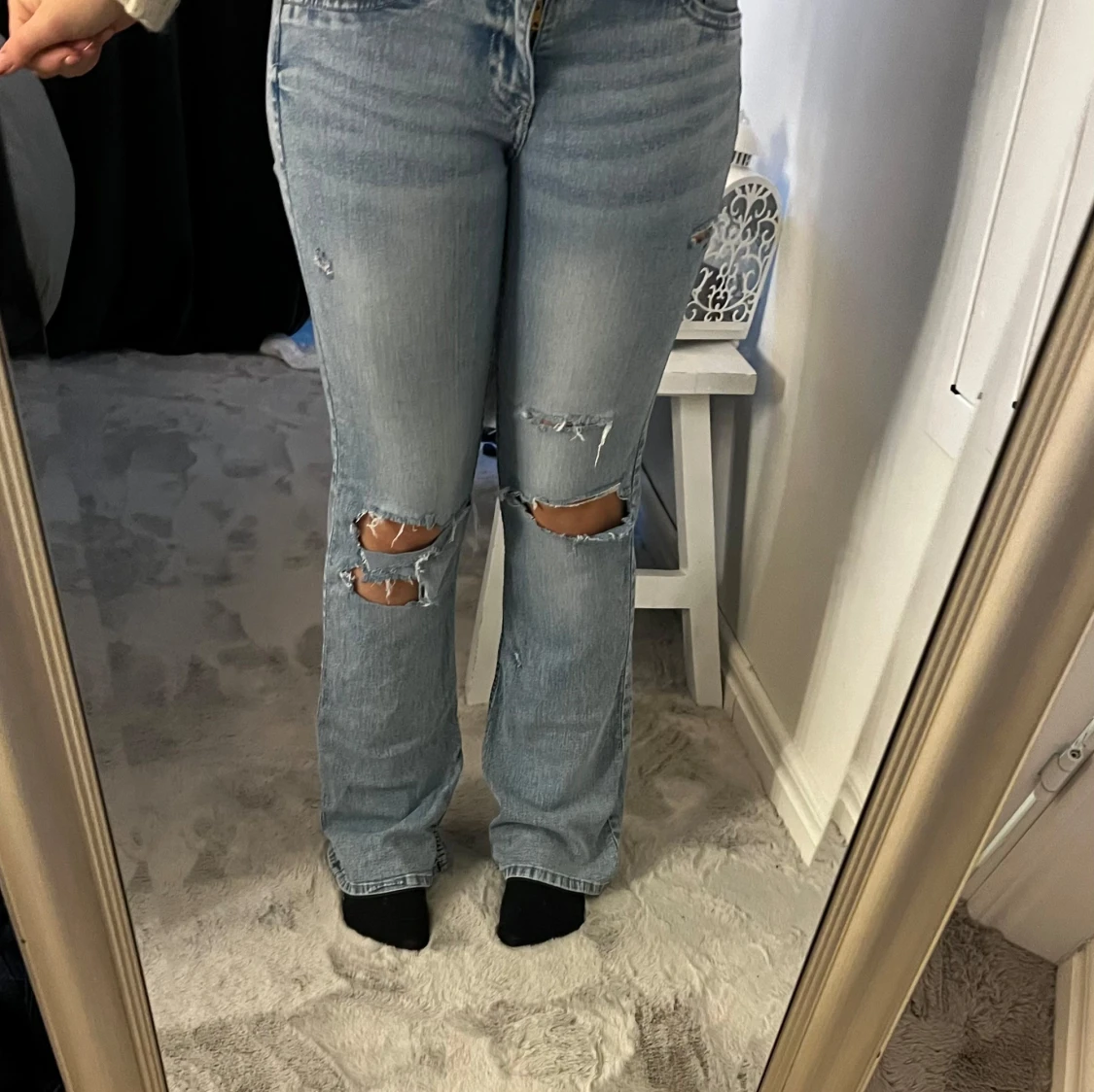 Ljusblå slitna bootcut jeans