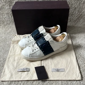 Valentino Open skor - Hej! Marinblå Valentino open skor i modellen rockstud säljes. Tecken på användning finns som visas på bilderna. Smått repaintade på främre delen. Box, 2st dustbags och kort medföljer vid köp! Några nitar har lossnat som syns på bilderna men också vid andra sidan på skorna. Nypris: 8500kr. Som äkthetsbevis så finns det en kod under ”plösen” som man kan få verifierad på Valentinos hemsida eller i butik. skriv vid minsta intresse av köp! 😊mvh DC 🔹