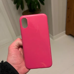 iPhone X/XS Skal Rosa - Snyggt rosa skal för iPhone X/XS. Skalets yta är blank och i gott skick, med minimala tecken på användning. Perfekt för att skydda din mobil mot repor och stötar samtidigt som du ger den en personlig touch.
