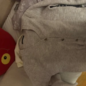 Beige stickad kofta  - Mysig beige stickad kofta  i storlek M. Koftan har långärmade ärmar, ribbade muddar och snygga knappar framtill. Perfekt för dig som gillar en chill och enkel stil med lite vintagevibe.