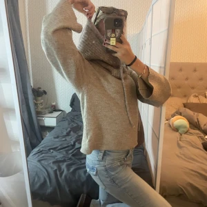 Beige stickad tröja  - Mysig beige stickad tröja. Tröjan har långa ärmar med ribbade muddar och en loose fit. Perfekt för kyliga dagar och enkel att styla med jeans eller leggings.