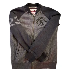 Grey superdry zip sweater - A great grey superdry zip up sweater without a hood in size M could fit a S. No stains nor holes. Sending within 2 days! Price can be discussed for quick purchase. OBSERVE: everything that seems to be in bad quality is actually how it is supposed to be so don’t worry. Width:53 cm and Length: 67cm
