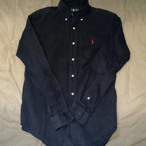 Mörkblå skjorta från Ralph Lauren - Mörkblå skjorta från Ralph Lauren i storlek S. Fint skick till ett bra pris. Nypris: 1995kr. Mitt pris: 299kr                  Vid frågor eller funderingar, tveka inte att höra av dig.