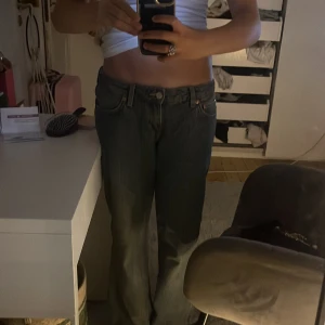 Blåa Weekday jeans bootcut - Säljer ett par blåa jeans från Weekday🤭 med bootcut-modell och låg midja. Jeansen har klassisk femficksdesign, dragkedja och knapp🤗 framtill samt en snygg skinnpatch bak i midjan🤪.  Lite mer av en baggy vibe skulle jag säga storlek w27 L34 pris kan diskuteras 