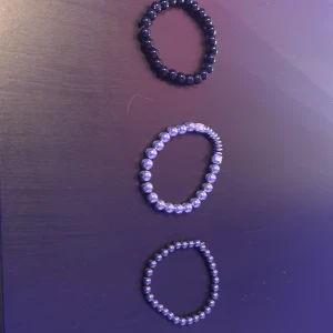 Set med tre pärlarmband i svart och silver - Säljer ett set med tre elastiska armband av pärlor. Ett armband är svart med glansiga runda pärlor, de andra två är i silverfärg – ett med större pärlor och fyrkantiga detaljer, det andra med mindre pärlor. Perfekt för att mixa och matcha till din stil. Kan köpas separat isåfall är det bara att skriva 