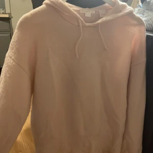 Ljusrosa stickad hoodie från Gina Tricot - Stickad ljusrosa hoodie från Gina Tricot med huva och snörning. Tröjan är stickad och har ribbade muddar vid ärmslut och nederkant. Perfekt för dig som gillar en chill och cozy stil.(storlek 170, skulle säga att de motsvarar s-m)😊