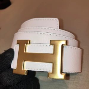 Vändbart H-bälte  - Vändbart bälte svart/vit perfekt till alla möjliga olika outfits från vit till svart. Perfekt för dig som vill ha en stilren look men ändå se fräsch ut. 