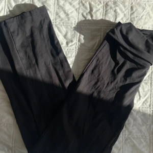 Svarta leggings från SOC, storlek M - Svarta leggings från SOC med diskret logga på höften. Stretchigt material som sitter skönt och följer kroppen, perfekt för träning eller chill. Hög midja och slät design utan synliga sömmar framtill. Snygga och enkla att matcha med din favorit-hoodie.