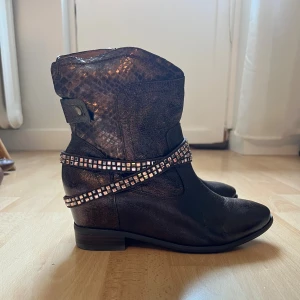 Bruna boots med ormskinnsmönster och nitar - Bruka boots som är perfekt nu till hösten. Aldrig använda, endast testade.