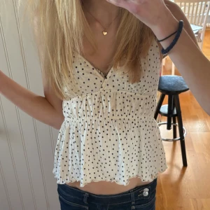 Prickig vit linnetopp med volang - Supersöt vit linnetopp med svarta prickar 💕💕 aldrig använd 