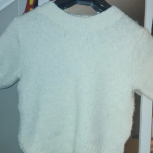 Vit stickad tröja från Gina Tricot XS - Supermysig vit stickad tröja från Gina Tricot i storlek XS. Tröjan har korta ärmar, rund halsringning och är fluffig i materialet. Perfekt för lager-på-lager och passar till allt. Enkel och stilren design som är lätt att matcha.
