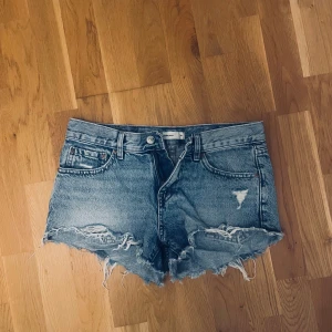 Jeansshorts - Säljer ett par blå jeansshorts från gina tricot. Köpta sommaren 2024❣️ Är i storlek 34 och fint skick