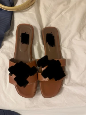 Bruna sandaler - Snygga bruna sandaler. Platt sula och stilren design som passar perfekt till sommaren. Tillverkade i syntetmaterial med vita sömmar som detalj. Köpt för 800