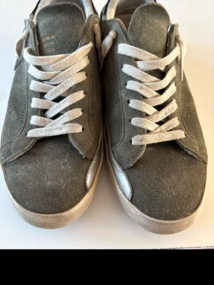 Golden goose - Säljer ett par snygga gröna sneakers från Golden Goose med vit sula och vita snören. Skorna har en rund tå och är tillverkade i mocka med svart detalj på hälen. Perfekta för dig som gillar stilrena och coola sneakers. Dem är lite slitna under till. Men annars riktigt bra skick. Nypris ca 4800kr mitt pris 499. Priset är ej hugget i sten. Hör gärna av er vid minsta lilla fundering. 