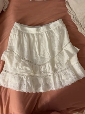 Vit volangkjol  - Supersöt vit kortkjol med volanger och fina detaljer.