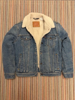 Levi's vintage jeansjacka - Klassisk blå jeansjacka från Levi's. Jackan har två bröstfickor med knappar, sidofickor och knappstängning framtill. Perfekt oversized look och riktigt mysig till höst och vinter.