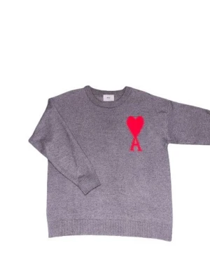 Grå stickad tröja från Ami Paris - Grå stickad tröja från Ami Paris med rund halsringning och ribbade muddar. På bröstet finns ett rött hjärta med bokstaven 'A' broderat. Tröjan har en avslappnad passform och är perfekt för lager på lager. Materialet ser ut att vara mjukt och bekvämt.
