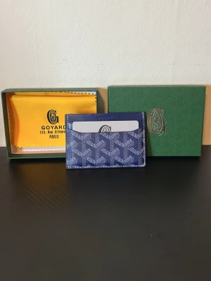 Blå Goy4ard plånbok card holder - Snygg blå plånbok/card holder från Goy4ard med ikoniskt mönster i vitt och grått. Plånboken har flera kortfack och är tillverkad i exklusivt skinn. Perfekt för dig som vill ha en stilren och lyxig accessoar.