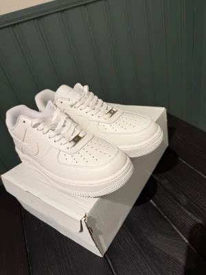 Nike Air Force 1 vita sneakers - Säljer ett par helt nya vita Nike Air Force 1. Fick dem i present men de passar tyvärr inte. Skorna är oanvända, i nyskick och i storlek 42. Hör av dig vid intresse