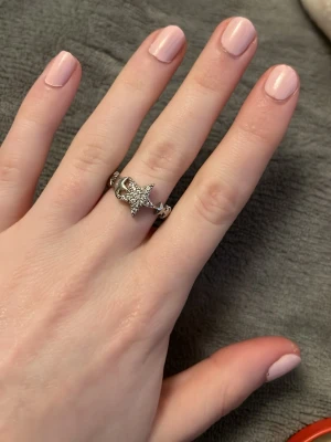 Silverfärgad ring med stjärna och måne - Unik silverfärgad ring med en gnistrande stjärna och måne dekorerad med små klara stenar. Ringen har en öppen design och är justerbar i storlek. Perfekt för dig som gillar detaljer och vill ha något som sticker ut.Vid köp av fler ringar kan jag slå ihop annonserna så frakten blir billigare.