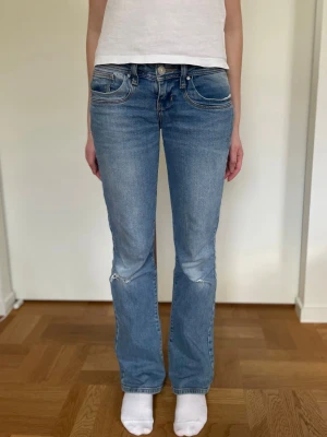 Blå bootcut jeans med hål på knäna ltb W25 L32 valerie - Snygga blå lågmidjade bootcut jeans från ltb i modellen valerie. Hål på knäna som man säkert kan göra ännu större. Perfekta för en avslappnad och trendig look. Jag på bilden är 163-164cm. Storlek w25 l32