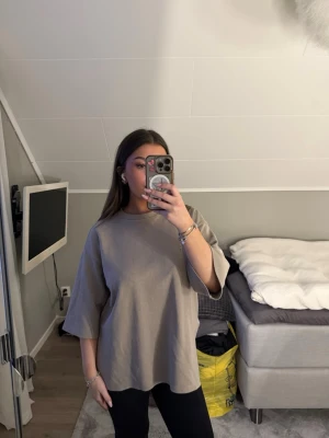 Oversized beige t-shirt - Snygg oversized beige t-shirt med rund hals och korta ärmar. Enkel och stilren design som passar perfekt till jeans. Skön och avslappnad passform, perfekt för en chill vardagslook.