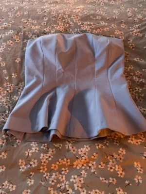 Ljusblp tubtopp från zara - Snygg & trendig ljusblå tubtopp med axelbandslös design och markerade sömmar som ger en strukturerad look. Köpt i marbella och är i st M men passar även S! I nyskick 🥰🥰