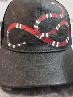 Svart Gucci keps med ormtryck - Snygg svart keps från Gucci kommer helt ny, kommer med kvitto dustpåse tag o allt 
