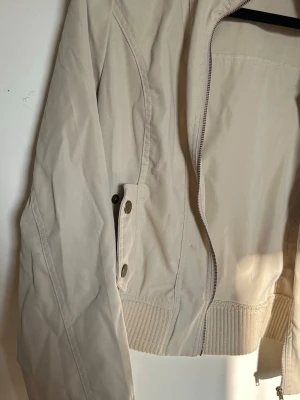 Beige Tunn Jacka - knappt använd, fickan gick dock sönder efter en tvätt men annars är den i jätte fint skick. asiatisk storlek L, sitter som en XS-S.