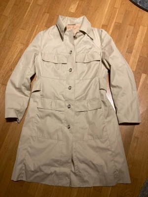 Vintage kappa  - Beige kappa med sleif bak Blankt foder. Finns ingen strl men uppskattar till S
