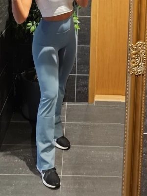 Blå bootcut leggings med hög midja - Snygga blå leggings med bootcut och hög midja. Stretchigt material som sitter tight upptill och släpper ut vid benen för en trendig siluett. Perfekta för dig som vill ha både komfort och stil i vardagen. Har endast haft på mig dem 2 gånger. Ord.pris 800kr 