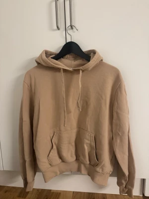 Beige hoodie från H&M Basic XS - Snygg beige hoodie från H&M Basic i storlek XS. Hoodien har en ficka framtill, passar allt.