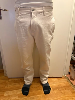 Zara Beige/Off-White Slim Fit Jeans - Size 38 - Selling a pair of clean and versatile Zara jeans in a stylish off-white/beige shade. These feature a modern slim-to-straight fit and a classic metal button closure.  The fabric has a high-quality feel, making them perfect for both casual streetwear and a more "dressed-up" summer look. They are in excellent condition with no visible marks or signs of heavy wear.  Brand: Zara  Size: 38 (EU)  Color: Beige / Off-White / Cream  Condition: Very good / Like new  Features: Standard 5-pocket design, belt