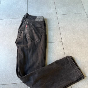 Svarta Levi's 514 jeans, straight fit - Svarta Levi's 514 jeans med klassisk femficksdesign och rak passform. Jeansen har en diskret Levi's-lapp bak i samma ton som tyget och är tillverkade i slitstarkt bomullsmaterial. Perfekt för dig som gillar en enkel och clean look.