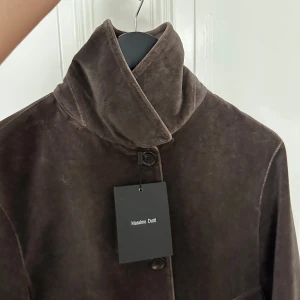 Viral mockajacka från Massimo Dutti - Snygg eftertraktad mockajacka från Massimo Dutti med hög krage och stora fickor framtill. Jackan är croppad och har knäppning med knappar. Perfekt för dig som vill ha en stilren och trendig look med exklusiv känsla. Gick super viralt och den kollektionen sälj på vestiare för ca 5000kr 
