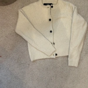 Krämvit stickad kofta från Vero Moda - Helt oanvänd kofta från vero Moda. Jätte fin till hösten. Storlek XS