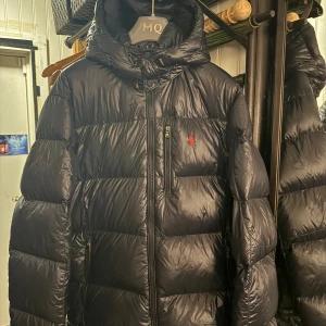Polo Ralph Lauren Dunjacka - Navy glossy dunjacka från Ralph Lauren i storlek L. Inköpt från Zalando förra vintern(kvitto finns). Använd endast fåtal gånger. 