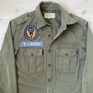 Vintage Ralph Lauren militärjacka - Sjukt fet vintage Ralph Lauren militärjacka/ overshirt i fint skick 🙌 Jackan är i storlek S men passar nog även på någon som brukar ha M 👍 Har en liten slitning mellan de två nedersta knapparna, skriv vid fråga ✌️!