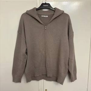 Grå stickad half zip tröja från Zara - Säljer en grå stickad tröja från Zara med half zip och krage. Tröjan har en loose passform, ribbade muddar och långärmade ärmar. Perfekt för lager-på-lager och chill stil. Fråga gärna om fler bilder eller info! 