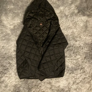 Svart quiltad jacka med huva - Hej! Detta är en väldigt fin jacka som man kan använda medans man tillexempel rider eller om det är kallt ute.kvaleten är väldigt fin samt passform på jackan.