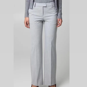 Ljusgrå kostymbyxor med bootcut - Snygga ljusgrå kostymbyxor med bootcut-snitt och hög midja . Dom är helt oanvända, prislappen ligger kvar. 