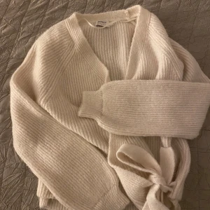 Beige ribbad kofta från ONLY - Mysig beige kofta från ONLY med ribbad struktur och knytband i midjan. Koftan har långärmad design och en avslappnad passform, perfekt att slänga på sig när det är kyligt. Stilren och enkel att matcha med det mesta.  Pris kan diskuteras 