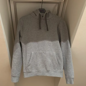 Syna World hoodie - Säljer denna gråa Syna World hoodien i storlek S. Hoodien har använts väldigt sparsamt och det finns inga defekter alls. Orginella påsen samt taggar och stickers medföljer självklart. Priset är inte satt i sten och kan sänkas vid snabb affär. Skriv ifall ni behöver bilder eller har andra funderingar. 